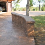 A concrete bench sitting on top of a patio.