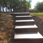 A concrete staircase in the middle of a field.