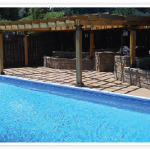 A pool with an outdoor seating area and patio.