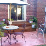 A patio with an umbrella and chairs outside