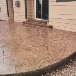 A patio with a stone pattern and a door.