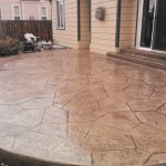 A patio with a large stone pattern on the side of it.