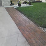 A brick walkway in front of a house.