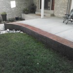 A patio with grass and rocks on the ground