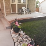 A patio with rocks and plants in the middle of it.