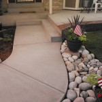 A walkway with flagstone and rocks leading to the house.