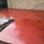 A red floor with some brown spots on it