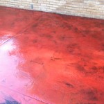 A red floor with some brown spots on it