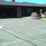 A driveway with concrete and brick in the middle of it.