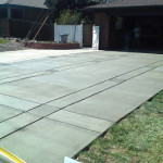 A concrete slab that has been laid in the middle of a driveway.