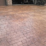 A driveway with brick and concrete pavers in the middle of it.