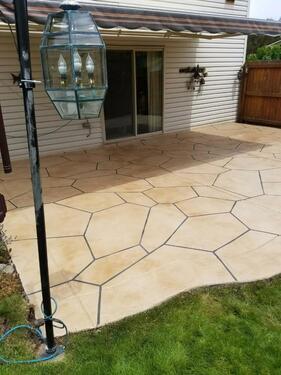 A patio with a large stone pattern on the ground.