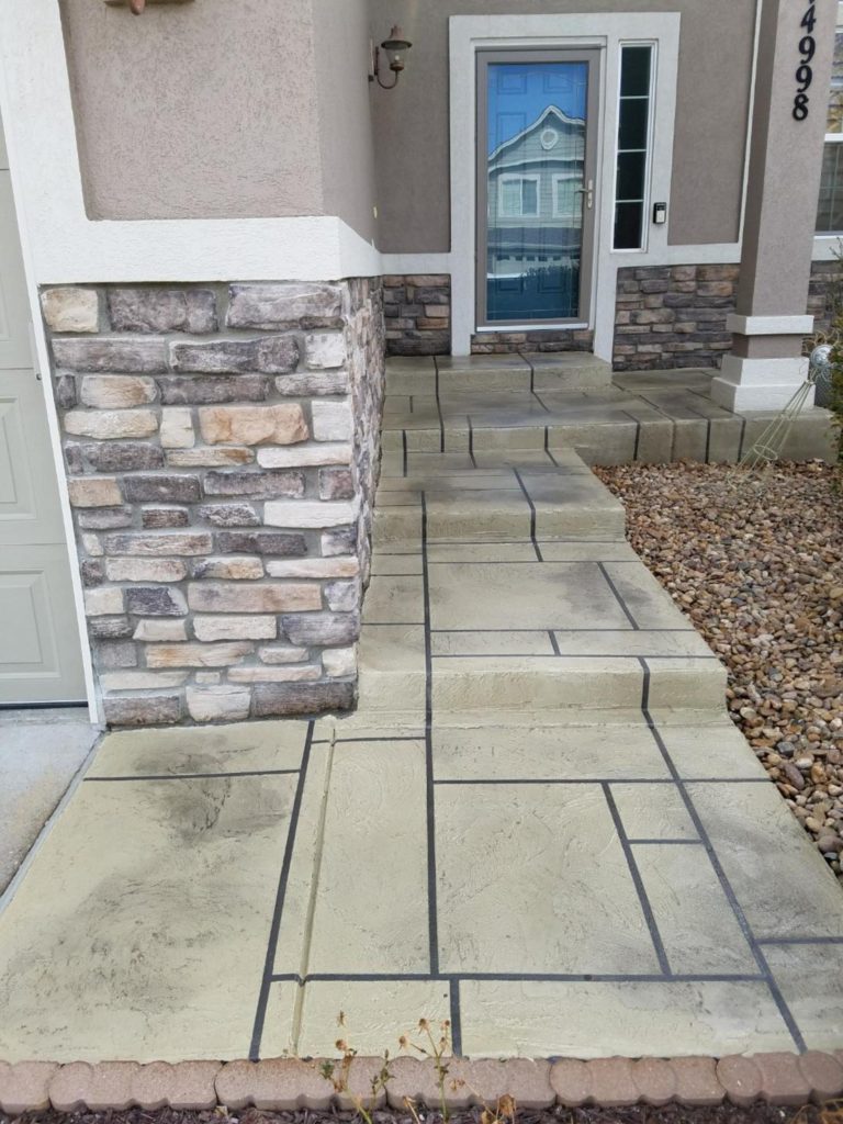 A walkway with stone steps and brick columns.