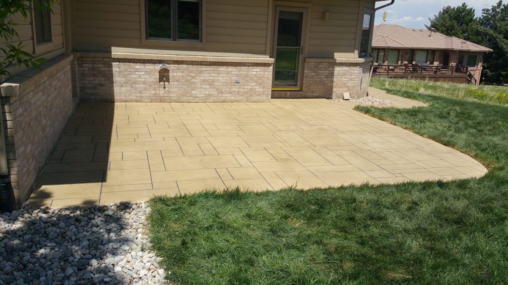 A patio with grass and stones in the middle of it.