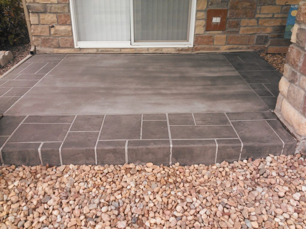 A patio with stone and tile on the ground.